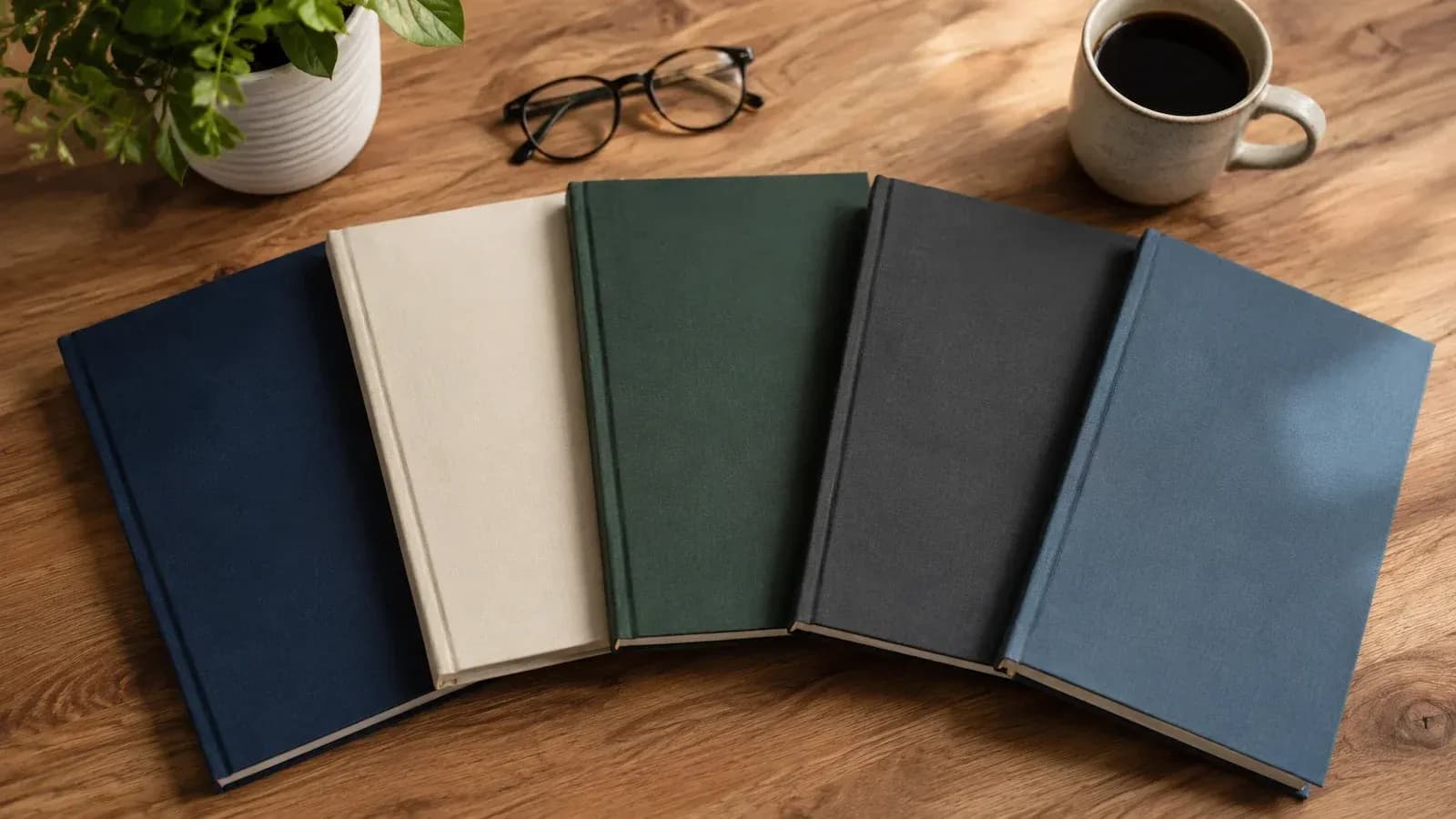 Stack of financial education books on a desk with reading glasses and coffee